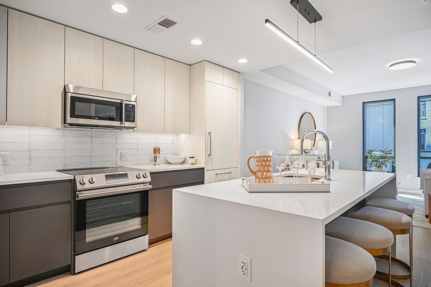 Mount Vernon Triangle, Washington, DC, Luxury Apartments Near Safeway - Claret - Living Room With Luxury Plank Flooring, Couch, Armchair, Round Coffee Table, Side Table, Lamps, And Large Windows.