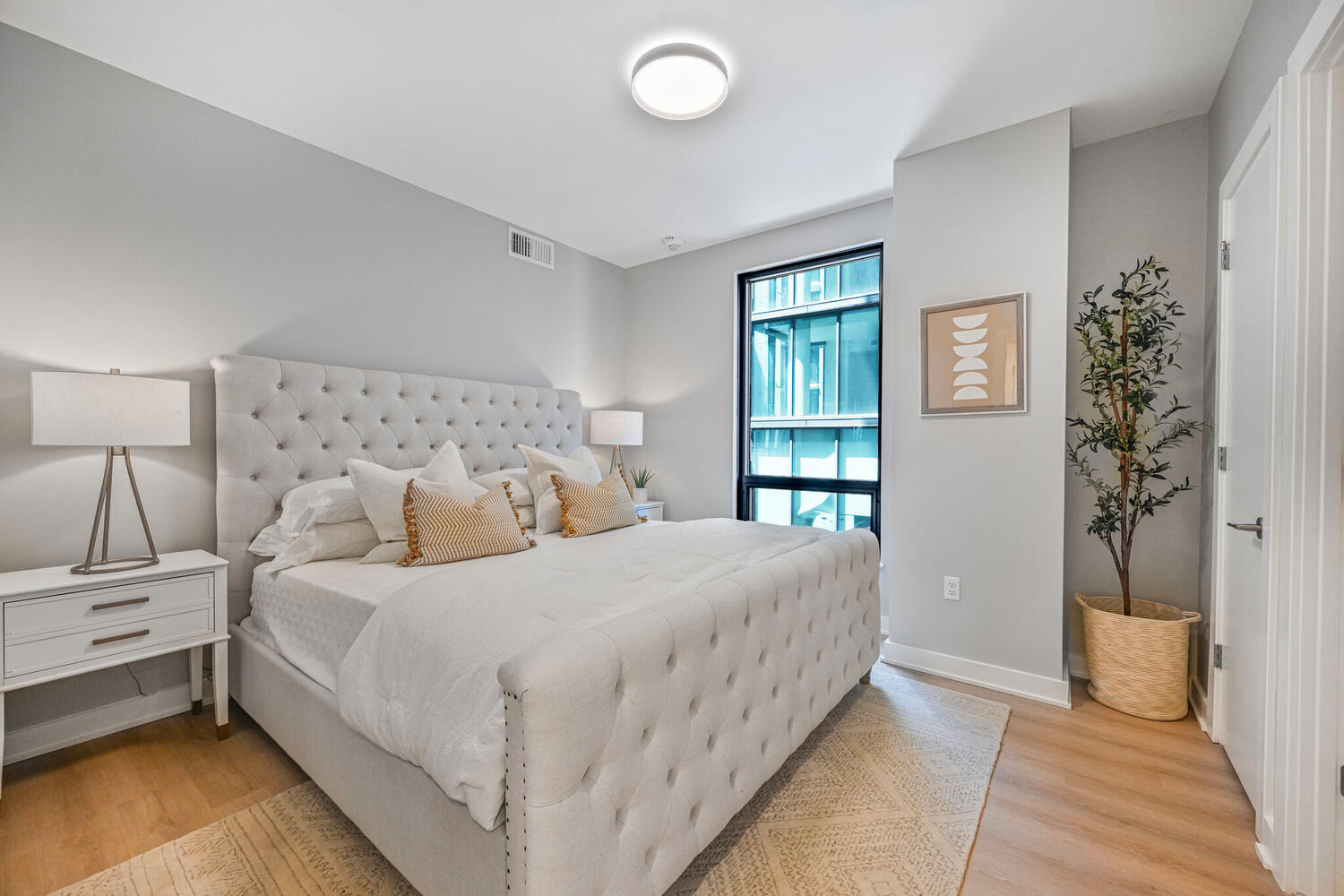 Mount Vernon Triangle, Washington, DC, Luxury Apartments Near Safeway - Claret - Living Room With Luxury Plank Flooring, Couch, Armchair, Round Coffee Table, Side Table, Lamps, And Large Windows.