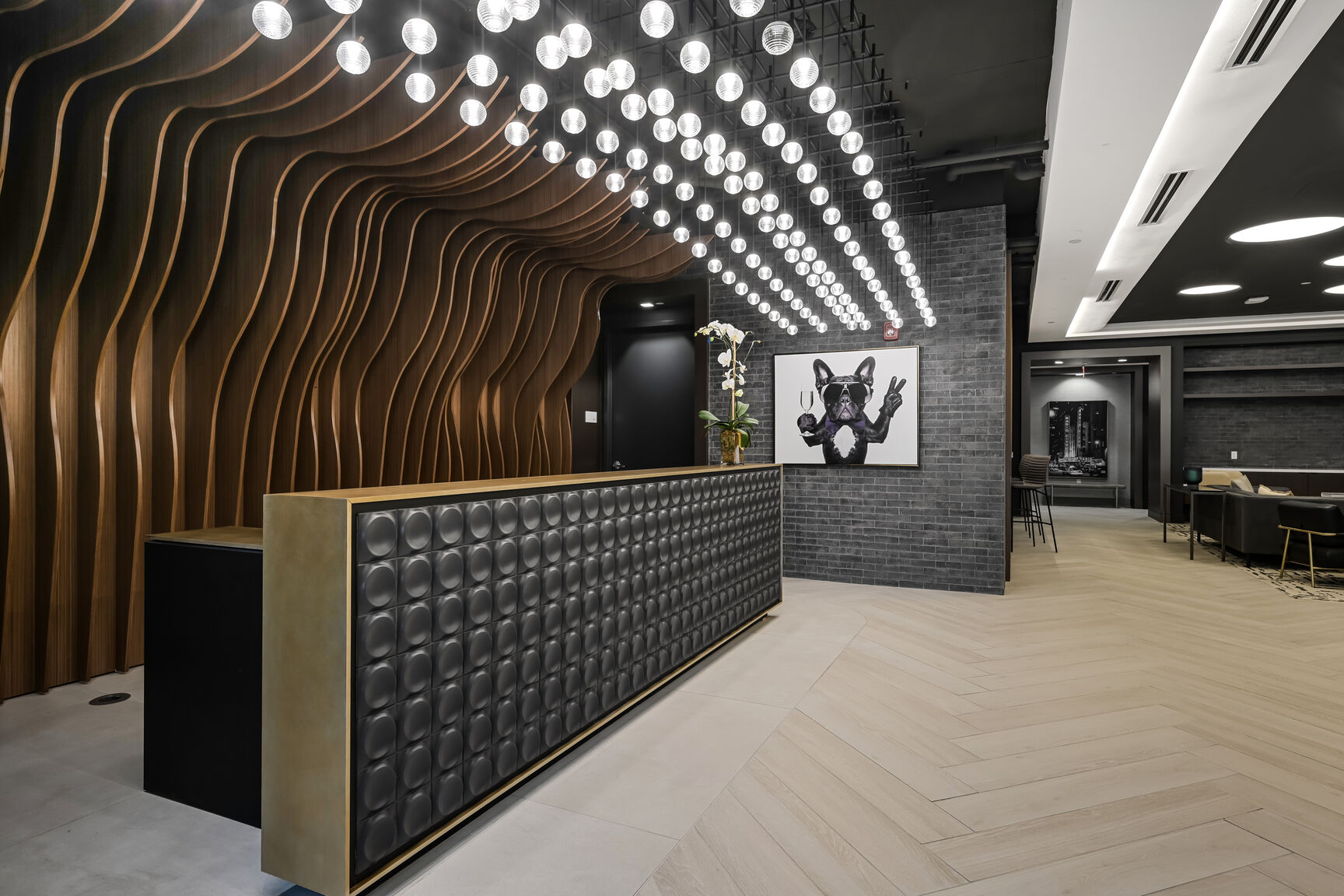 Mount Vernon Triangle, Washington, DC, High-Rise Apartments Near Georgetown University Law Center - Claret - Lobby Area With Reception Desk, Light-Colored Tiles, Pendant Lighting, Wavy Feature Wall.